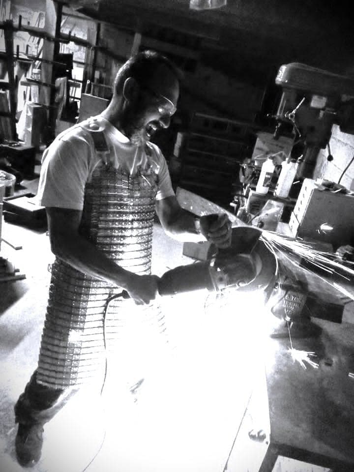 Gerbe d'étincelles sous la meuleuse dans l'atelier du Résiliant : l'enlèvement de matière à la machine reste un geste d'atelier, photo en noir et blanc.